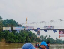 Peduli Tradisi Lomba Pacu Perahu, Baliho Paslon Syukur-Khafid Meriahkan Jembatan Gantung Dusun Tuo Pamenang